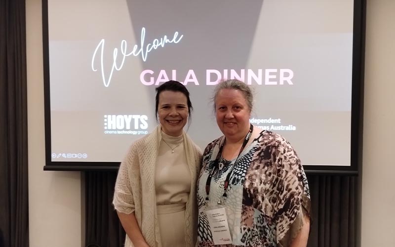 Two people standing in front of a sign for the ICA welcome gala dinner
